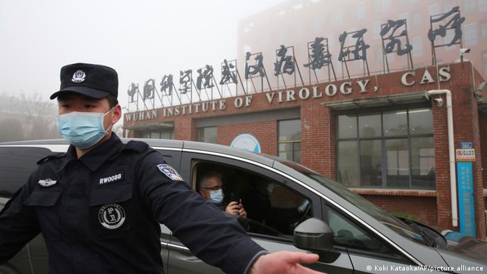 Un guardia de seguridad revisa la puerta del Instituto de Virología de Wuhan mientras un vehículo con expertos de la Organización Mundial de la Salud (OMS) entra en Wuhan, provincia de Hubei, China, el 3 de febrero de 2021.