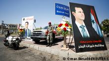 26.05.2021
A Syrian military police officer stands near posters depicting Syria's President Bashar al-Assad, during the country's presidential elections in Damascus, Syria, May 26, 2021. REUTERS/Omar Sanadiki