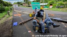 TOPSHOT - Demonstrators block the Panamerican highway to protest against the government of President Ivan Duque, between Buga and Cali, in Valle del Cauca department, Colombia, on May 26, 2021. - Officially, 43 people have died in clashes since protests started, initially against a proposed tax reform that has since been withdrawn. Demonstrations have continued in the face of a violent police crackdown that has drawn international condemnation. (Photo by LUIS ROBAYO / AFP) (Photo by LUIS ROBAYO/AFP via Getty Images)