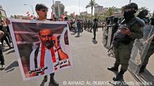 Iraqi security forces deploy during a demonstration in Tahrir Square in Baghdad on May 25, 2021, to demand accountability for a recent wave of killings targeting activists. The placard depicts renowned anti-government activist Ihab al-Wazni (Ehab al-Ouazni), who was shot dead in an ambush earlier this month. - Thousands of Iraqis demonstrated in the capital to demand justice over a wave of deadly attacks on pro-democracy activists and journalists. Waving portraits of victims, gunned down with silencers by unknown assailants, protesters converged on the capital's main squares including Tahrir, as police were deployed in force. (Photo by Ahmad AL-RUBAYE / AFP) (Photo by AHMAD AL-RUBAYE/AFP via Getty Images)