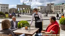 BERLIN, GERMANY - MAY 21: People sit outside at a restaurant near Brandenburg Gate for the first time this year during the coronavirus pandemic on May 21, 2021 in Berlin, Germany. Authorities are easing lockdown measures across Germany, enabling restaurants to offer outdoor service, hotels to accommodate tourists, cultural institutions to perform and other activities to resume. Covid infection rates have been falling consistently and the national average is now below 80 per 100,000 over a seven-day period. Meanwhile the pace of vaccinations is still climbing, with approximately 40% of the population having received a first dose. (Photo by Maja Hitij/Getty Images)