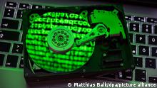 ILLUSTRATION - Ein Computercode in grüner Schrift spiegelt sich am 06.11.2015 in der Scheibe einer geöffneten Festplatte in Norden (Niedersachsen). Foto: Matthias Balk/dpa