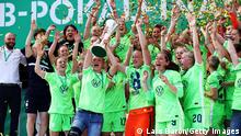 COLOGNE, GERMANY - MAY 30: Alexandra Popp and Almuth Schult of VfL Wolfsburg lift the DFB Cup as their team mates celebrate victory in the Women's DFB Cup Final match between Eintracht Frankfurt and VfL Wolfsburg at RheinEnergieStadion on May 30, 2021 in Cologne, Germany. (Photo by Lars Baron/Getty Images)