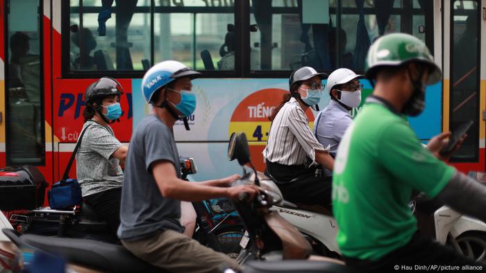 Personnes portant des masques sur les motos à Hanoï