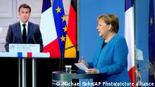 French President Emmanuel Macron is seen on a video screen during a joint press conference with German Chancellor Angela Merkel, right, as part of a virtual Plenary Session of the Franco-German Council of Ministers in Berlin, Germany, Monday, May 31, 2021. (AP Photo/Michael Sohn, pool)