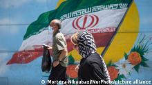 30.05.2021
Iranian people walk past an Iran flag in downtown Tehran on May 30, 2021. Iranians will vote to elect the new President on June 18 amid the new corona virus outbreak in Iran. (Photo by Morteza Nikoubazl/NurPhoto)