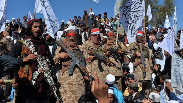 A group of villagers and Taliban members celebrate the signing of the 2020 peace deal