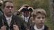 Film still 'We': a man looking though binoculars, two boys in the foreground. Film still 'We': a man looking though binoculars, two boys in the foreground.