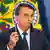 Jair Bolsonaro discursa segurando uma caneta