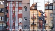 Wohnhäuser in der Kölner Innenstadt spiegeln sich in einer Glasfassade. Köln, 29.07.2020