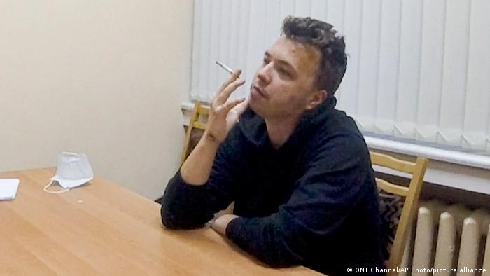 Raman Pratasevich smokes a cigarette while speaking from a detention center in a video. 