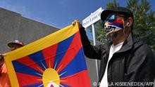 Activists hold the Tibetan flag underneath a street sign reading 'Dalai Lama street', close to a territory of the planned Chinese Fudan University campus, in 9th district, Ferencvaros of Budapest, Hungary on June 2, 2021. - Budapest has renamed streets around the planned site of a top Chinese university to protest an unwanted project forced on it by Prime Minister Viktor Orban's government, the city's mayor said. (Photo by Attila KISBENEDEK / AFP)