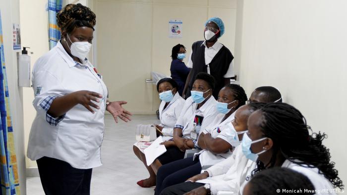 Mhudumu wa afya akizungumza na wenzake walipokuwa wanjiandaa kupokea chanjo chini ya mpango wa ugavi wa COVAX nchini Kenya 