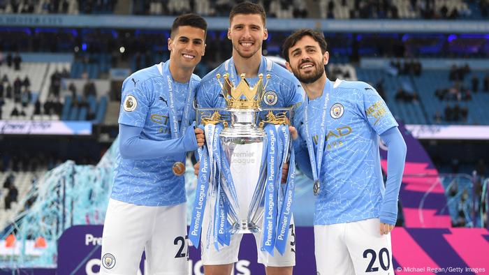 João Cancelo, Ruben Dias e Bernardo Silva festejam com o Troféu da Premier League 