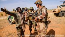 Barkhane, operation Eclipse. In the middle of the Sahelian desert, a joint patrol between the French soldiers of the Barkhane force and the soldiers of the Malian Armed Forces (FAMa) of the G5 Sahel. One Malian soldier talk to a French officer. Mali, Gourma (Tri-border region), January 2021. Photography by Frederic Petry / Hans Lucas. Barkhane, operation « Eclipse ». Au milieu du desert Sahelien, une patrouille conjointe entre les soldats francais de la force Barkhane et les soldats des Forces Armees Maliennes (FAMa) du G5 Sahel. Un soldat maliens s entretienne avec un officier francais. Mali, Gourma (region des trois frontieres), janvier 2021. Photographie de Frederic Petry / Hans Lucas.