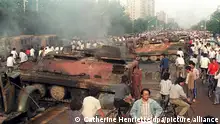(FILES) Beijing residents inspect the interior of some of over 20 armoured personnel carrier burnt by demonstrators to prevent the troops from moving into Tiananmen Square 04 June 1989. On the night of 03 and 04 June 1989, Tiananmen Square sheltered the last pro-democracy supporters. Chinese troops forcibly marched on the square to end a weeks-long occupation by student protestors, using lethal force to remove opposition it encountered along the way. Hundreds of demonstrators were killed in the crackdown as tanks rolled into the environs of the square. dpa +++ dpa-Bildfunk +++