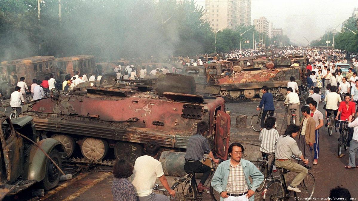Beijing residents inspect the interior of some of over 20 armoured personnel carrier burnt by demonstrators to prevent the troops from moving into Tiananmen Square 04 June 1989
