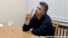 Das vom belarussischen ONT-Kanal zur Verfügung gestellte Videostandbild zeigt den Aktivisten und Blogger Raman Pratasewitsch, der an einem Tisch sitzt und eine Zigarette raucht. In einem einstündigen Video, das auf dem staatlichen Sender ONT ausgestrahlt wurde, wird der Regimekritiker in einem Haftzentrum gezeigt. (zu dpa Belarussisches Fernsehen zeigt Interview mit inhaftiertem Blogger) +++ dpa-Bildfunk +++