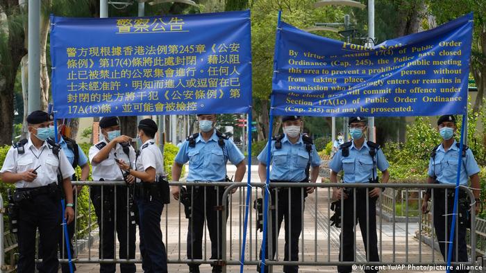 Police officers raise warning banners at Hong Kong Victoria Park