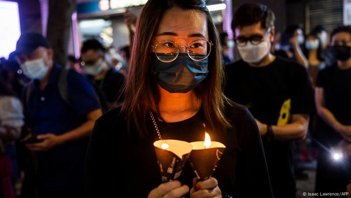 A woman holds candles in the Causeway Bay district of Hong Kong