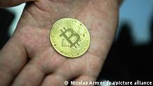 Ein Mann hält eine nachgemachte Münze mit dem Bitcoin-Logo in den Händen. El Salvador will die Kryptowährung Bitcoin zu einem gesetzlichen Zahlungsmittel machen. (zu dpa: El Salvador will Bitcoin zum gesetzlichen Zahlungsmittel machen) +++ dpa-Bildfunk +++