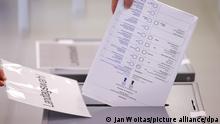 Eine Frau wirft ihren Stimmzettel in eine Urne in einem Wahllokal. Die Wahl zum neuen Landtag in Sachsen-Anhalt ist die letzte Landtagswahl vor der Bundestagswahl im September 2021. +++ dpa-Bildfunk +++