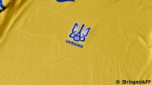 A picture taken on June 6, 2021 shows a EURO 2020 jersey of the Ukrainian national football team. - Ukraine provoked Moscow's ire on June 6, 2021 as its football federation unveiled Euro 2020 uniforms that feature Russian-annexed Crimea and nationalist slogans. The uniforms in the blue-and-yellow colours of the Ukrainian flag feature the silhouette of Ukraine that includes Russia-annexed Crimea and the separatist-controlled regions of Donetsk and Lugansk as well as the words Glory to Ukraine! Glory to the Heroes! (Photo by STRINGER / AFP)