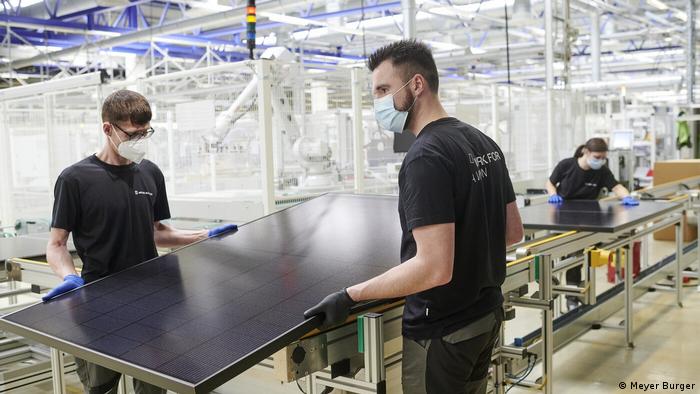 Arbeiter halten modernes Modul in der deutschen Solarfabrik von Meyer Burger bei Dresden