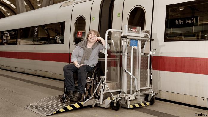 Eileen Lensch sitzt mit ihrem Rollstuhl auf einer Rampe vor der Tür eines Zuges