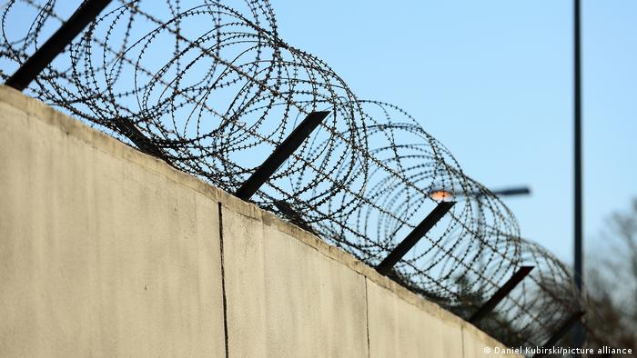 Колючая проволока на тюремной стене