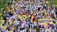 BOGOTA, COLOMBIA - MAY 30: Supporters of the government of President Ivan Duque wearing white t-shirts, holding white flowers, Colombian flags and signs in support of public forces take part in a movilization against violence on May 30, 2021 in Bogota, Colombia. According to José Uscátegui of Centro Democrático, public forces have suffered 2 casualties and around 1,000 police officers have been affected. 'Yo marcho por los héroes' is a mobilization called to raise the awareness of the damages caused by violence during the protests around the country which began on April 28. (Photo by Guillermo Legaria/Getty Images)