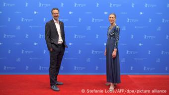 Sutradara Berlinale Carlo Chatrian dan Mariette Rissenbeck berdiri di atas karpet merah.