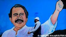 FILE PHOTO: A man, wearing a face mask for protection against the coronavirus disease (COVID-19), walks by a mural depicting Nicaraguan President Daniel Ortega, in Managua, Nicaragua March 30, 2020. Picture taken March 30, 2020. REUTERS/Oswaldo Rivas/File Photo