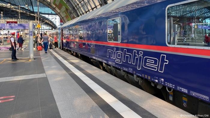 Trem azul inscrito Nightjet em plataforma de estação