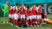 Denmark's players react as their teammate Christian Eriksen lays on the ground during the Euro 2020 soccer championship group B match between Denmark and Finland at Parken stadium in Copenhagen, Denmark, Saturday, June 12, 2021. (Wolfgang Rattay/Pool via AP)