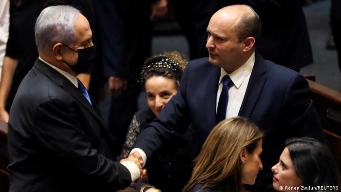 Head of Oposition Benjamin Netanyahu and Israel Prime minister Naftali Bennett shake hands following the vote