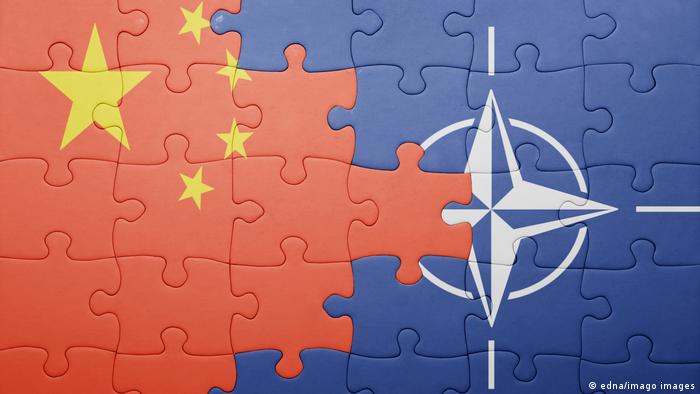 Ein Puzzle, in dem die Flagge Chinas wie ein Keil in die Flagge der NATO hineinragt