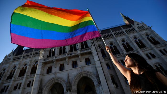 Woman waving LGBTQ flag in Budapest