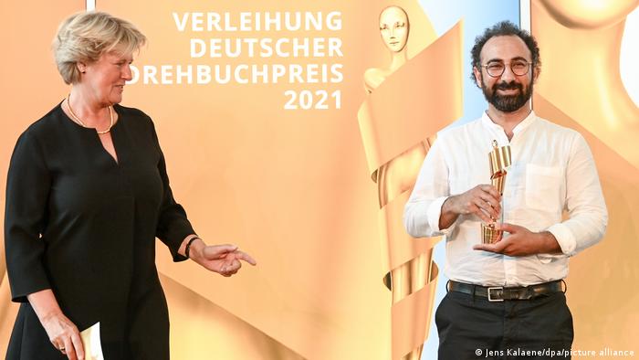 بهروز کرمی‌زاده جایزه بهترین فیلمنامه آلمان را از مونیکا گروترز، وزیر فرهنگ آلمان دریافت می‌کند