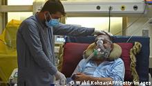 In this photograph taken on June 8, 2021, a family member comforts a Covid-19 coronavirus patient at the intensive care unit (ICU) of the Muhammed Ali Jinnah hospital in Kabul. - Officially Afghanistan has recorded fewer than 90,000 infections, with around 3,400 deaths, but health experts say a lack of testing and the refusal of patients to seek treatment hides the true figures. - To go with AFP story Afghanistan-Health-Virus, FOCUS by Mushtaq MOJADDIDI (Photo by Wakil KOHSAR / AFP) / To go with AFP story Afghanistan-Health-Virus, FOCUS by Mushtaq MOJADDIDI (Photo by WAKIL KOHSAR/AFP via Getty Images)