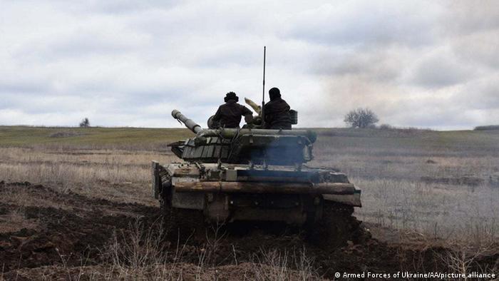 two men on a tank in Donbass region