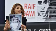 TOPSHOT - Ensaf Haidar holds a picture of her husband Raif Badawi after accepting the European Parliament's Sakharov human rights prize on behalf of her husband, at the European Parliament in Strasbourg, eastern France, on December 16, 2015. Raif Badawi is a Saudi Arabian blogger and author of a website, detained since 2012 on the charge of breaking Saudi technology laws and insulting religious figures. / AFP / PATRICK HERTZOG (Photo credit should read PATRICK HERTZOG/AFP via Getty Images)