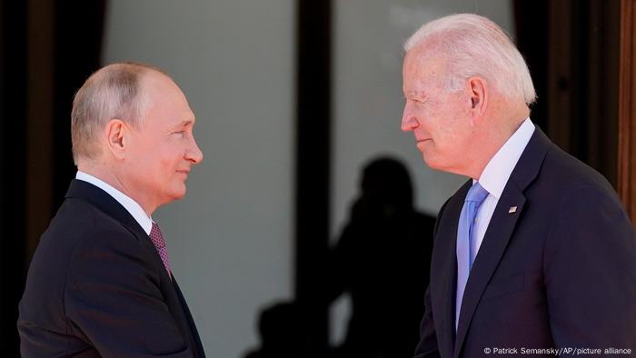 Putin and Baydet shake hands at a meeting in Geneva