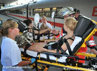 Medical professionals take a heat-stricken patient off the platform from a Deutsche Bahn train