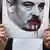 A protester in Minsk holding an altered image of autocratic leader Alexander Lukashenko