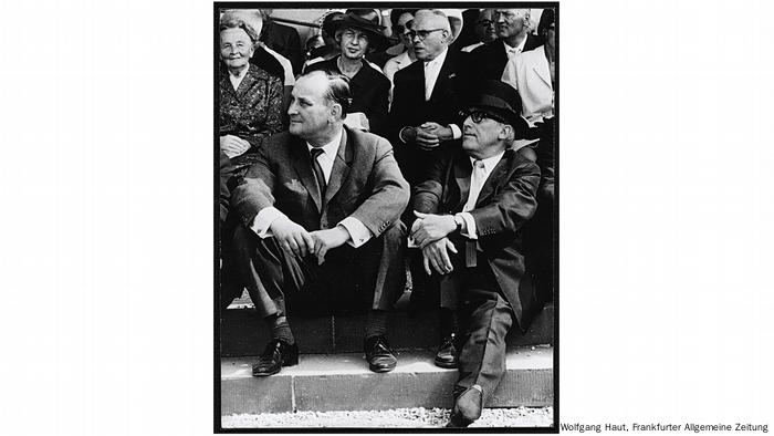 Historische schwarz-weiß Fotografie zeigt Männer in Anzügen, die auf einer Treppe sitzen. Historische schwarz-weiß Fotografie zeigt Männer in Anzügen, die auf einer Treppe sitzen.