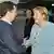 Russian President Dmitry Medvedev and German Chancellor Angela Merkel smile and shake hands