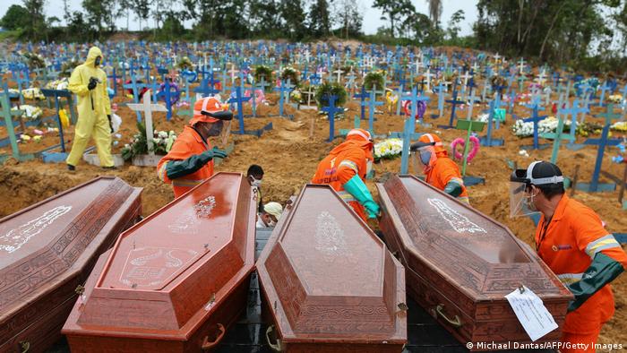 Coffins are unloaded to be buried in a mass grave at the Nossa Senhora cemetery in Manaus, Amazon state
