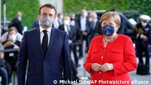 German Chancellor Angela Merkel, right, welcomes the President of France, Emmanuel Macron, left, for a meeting at the chancellery in Berlin, Germany, Friday, June 18, 2021. (AP Photo/Michael Sohn)