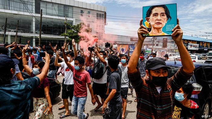 Protesters in Yangon hold up pictures of detained leader Aung San Suu Kyi